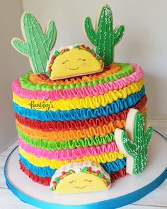 a cake decorated with colorful icing and cactus decorations