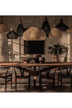 a dining room table surrounded by hanging lights