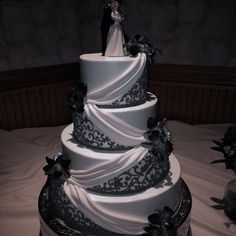 a three tiered wedding cake with black and white decorations on it's side