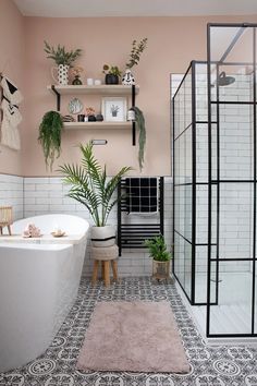 a bath room with a tub a shelf and plants