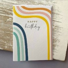 a card with the words happy birthday written on it and rainbows painted on it