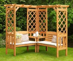 a wooden gazebo sitting on top of a lush green field