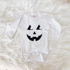 Add a little bit of Autumn cheer to your little's wardrobe with this fun Halloween onesie. This sweet polyester bodysuit is the perfect light layer for baby. It is unisex in design, perfect for girl and boy adventurers alike! Monochrome design goes with anything, pair with a cardigan for cooler nights. Available in long and short sleeves.This product is handprinted using nontoxic, water-based inks & heat pressed on a cozy onesie. Easy button-ups for changing time!This item comes in the follo Halloween Baby Onesies, Cricut Onesies, Pumpkin Onesie, Monochrome Baby, Baby Pumpkin, Baby Halloween Outfits, Custom Baby Clothes, Halloween Onesie, Custom Onesies