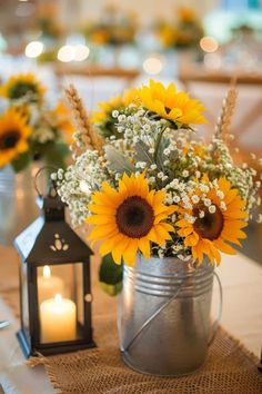 sunflowers and baby's breath in a metal pail on a table