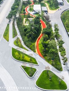 an aerial view of a park with green grass and red walkways in the middle