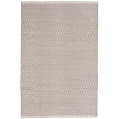 a white rug with grey herringbones on the bottom, and a light gray background