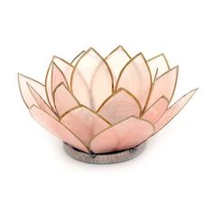 a pink and gold lotus flower sitting on top of a white table