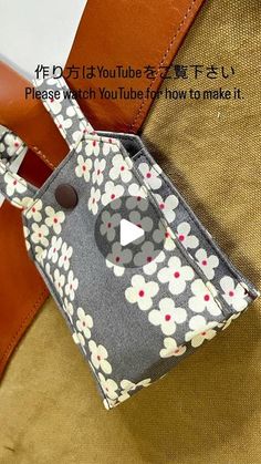 a purse with a flower pattern on it and a video player in the bottom right corner