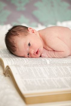 a baby laying on top of an open book