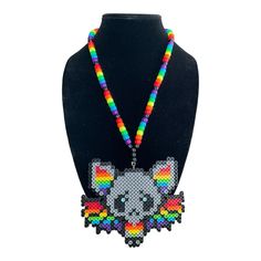 Add a pop of color to your festival or party outfit with this Rainbow Bat Kandi Necklace. Handcrafted with care, this beaded necklace features a unique design that will surely make you stand out from the crowd. The necklace is perfect for those who love to express themselves through their fashion choices and want to make a statement. Made by Byte Size Kandi, this necklace is a must-have for any jewelry collection. It is perfect for those who love to show off their love for all things colorful and vibrant. Whether you are attending a rave, party, or costume event, this necklace will complement your outfit perfectly. Handmade Rave Jewelry For Party, Handmade Adjustable Necklace For Festivals, Rainbow Beaded Necklaces For Party, Handmade Necklaces As Festival Gifts, Handmade Necklaces For Festival Gifts, Handmade Necklaces For Gifts And Festival, Handmade Necklace As Festival Gift, Handmade Necklace Gift For Festival, Colorful Beads Rave Festival Jewelry