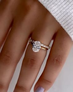 a woman's hand with two engagement rings on it