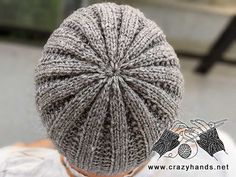 a person wearing a gray knitted hat with a knot on it's back