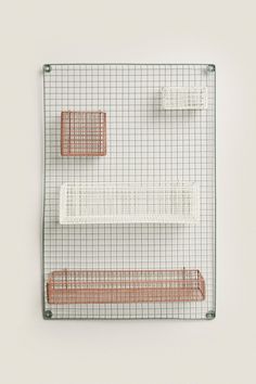 a wire shelf with three shelves on each side and two hooks attached to the wall