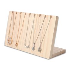 three necklaces are displayed on a wooden stand