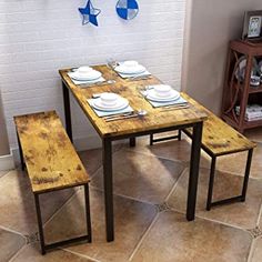 a wooden table and two benches in a room with tile flooring on the walls