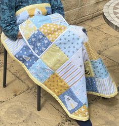 a person sitting on a chair with a quilt