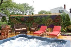 a hot tub sitting in the middle of a wooden deck next to a patio with chairs