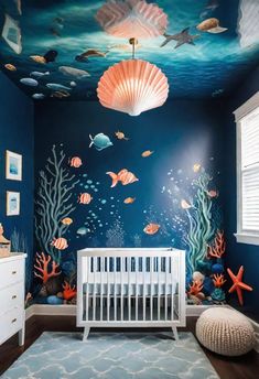 a baby's room decorated in blue and white with an underwater scene painted on the wall