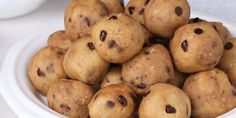 a white bowl filled with chocolate chip doughnuts