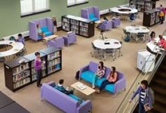 an aerial view of the library with purple couches and blue chairs, people sitting at tables