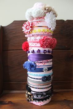 a stack of different colored ribbons sitting on top of a wooden bench