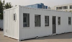 a large white container sitting on top of a parking lot next to a tall building