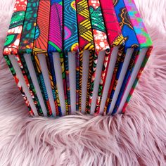 an open colorful book sitting on top of a pink fur covered floor