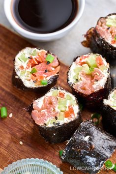 sushi rolls on a cutting board with dipping sauce