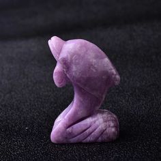 a purple sculpture sitting on top of a black surface