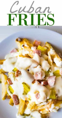 a white plate topped with french fries covered in gravy and bacon next to a green sign that says cuban fries