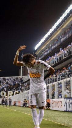 the soccer player is celebrating his goal in front of an empty stadium full of fans