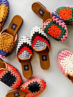 crocheted slippers are laid out on a white surface with different colors and patterns