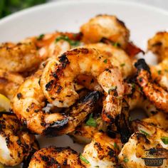 grilled shrimp on a plate with lemon wedges and parsley garnish