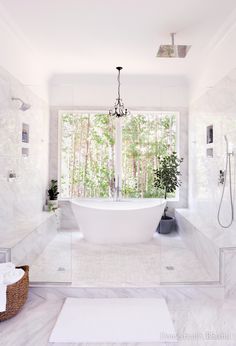 a large white bathroom with a tub and shower