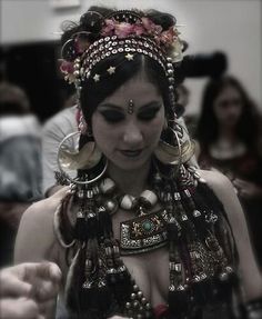 a woman wearing an elaborate headdress while holding a cell phone in her hand