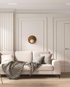 a living room with a white couch and some pillows on the floor next to it