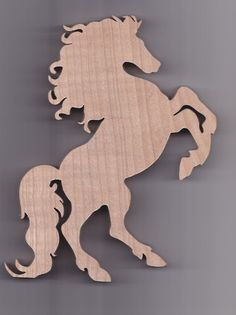 a wooden cutout of a horse with long manes and tail, standing on its hind legs