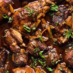 close up view of some meat and vegetables in a pan with sauce on it,