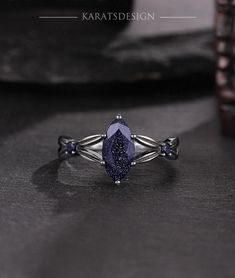 a purple stone ring sitting on top of a table