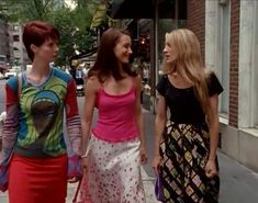 three women walking down the street talking to each other