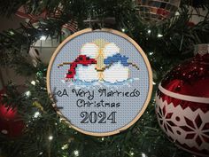 a cross stitch ornament hanging from a christmas tree