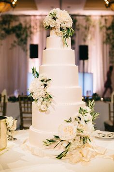 a wedding cake with white flowers and greenery