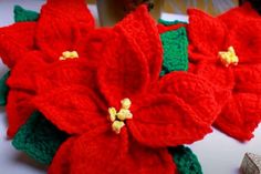 crocheted poinsettia flowers are displayed on a table