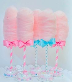 pink cotton candy lollipops with bows on them are sitting next to each other