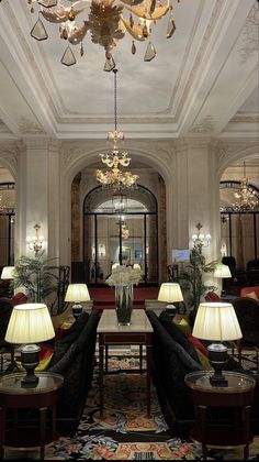 a fancy hotel lobby with chandeliers and couches