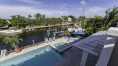 an aerial view of a house with a swimming pool and boat dock in the background