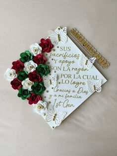 a decorated graduation cap with roses and butterflies on the front is sitting on a bed