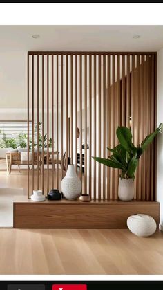 a living room with wooden slats and white vases