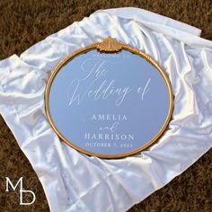 a wedding mirror on top of a white cloth