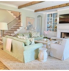 a living room filled with furniture and a fire place under a stair case next to a fireplace